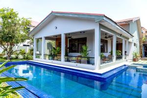 a villa with a swimming pool in front of a house at Château NaNa Willine in Accra