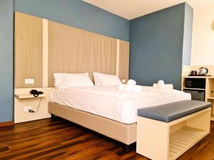 リモーネ・スル・ガルダにあるHotel all'Azzurroのベッドルーム1室(青い壁の大きな白いベッド1台付)