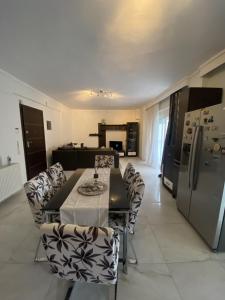 ein Wohnzimmer mit einem Tisch und Stühlen sowie eine Küche in der Unterkunft Comfortable Apartment With Parking in Thessaloniki