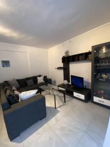 ein Wohnzimmer mit einem Sofa und einem TV in der Unterkunft Comfortable Apartment With Parking in Thessaloniki