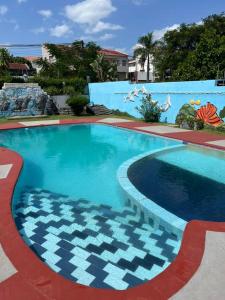 uma grande piscina com água azul em frente a um edifício em MATOLA AcCOMMODATION em Matola