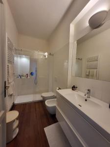 Baño blanco con lavabo y aseo en Villa Adelaide, en Baveno