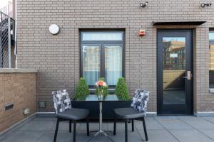 a table with two chairs in front of a building at The Melrose Hotel in Bronx