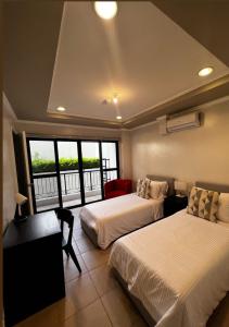 a hotel room with two beds and a balcony at Trillo Bay Villas in Kababae