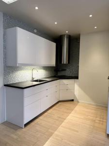 uma cozinha com armários brancos e um lavatório em Nyrenoverat i centrala Stockholm em Estocolmo
