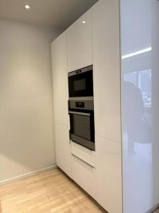 uma cozinha com armários brancos e um micro-ondas em Nyrenoverat i centrala Stockholm em Estocolmo