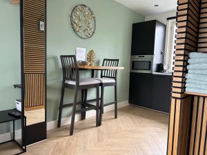 a small kitchen with a table and two chairs at Bnb de leeuw in Badhoevedorp