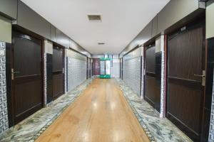 um corredor com portas de madeira e piso de madeira em OYO Jk Mahal em Sūbedārganj