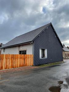 a black and white house with a wooden fence at Maison Valette in Roussillon-en-Morvan