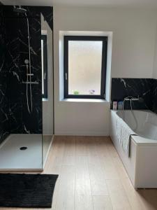 a bathroom with a bath tub and a window at Maison Valette in Roussillon-en-Morvan +8 photos