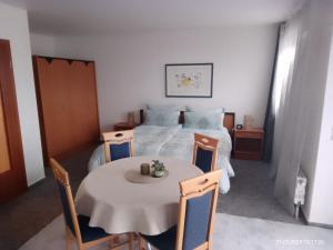 a bedroom with a bed and a table and chairs at Haus Meyne in Bad Fallingbostel