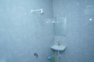 a white bathroom with a sink and a shower at Dwarkesh Farm&Resort in Somnath