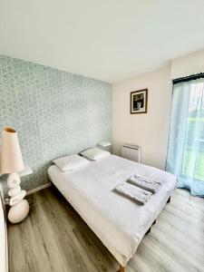 Ένα ή περισσότερα κρεβάτια σε δωμάτιο στο Superbe appartement avec jardin ensoleillé