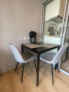 a dining room table with two chairs and a mirror at REWADI HOUSE in Hat Yai