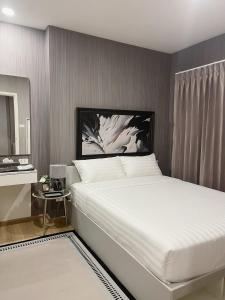 a bedroom with a white bed and a mirror at REWADI HOUSE in Hat Yai