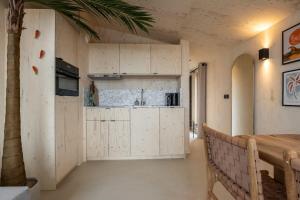 a kitchen with white cabinets and a table in a room at Hello Zeeland - Tiny House Zeeuwse Liefde 11 in Westkapelle