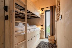 ヴェストカペレにあるHello Zeeland - Tiny House Zeeuwse Liefde 11の木造家屋内のベッドルーム(二段ベッド付)