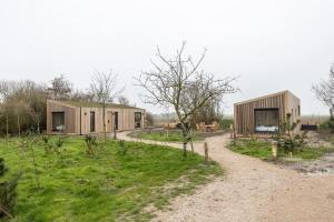 a group of modular houses on a dirt road at Hello Zeeland - Tiny House Zeeuwse Liefde 11 in Westkapelle