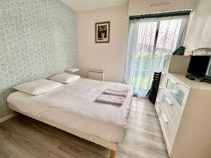 um quarto com uma cama, uma televisão e uma janela em Superbe appartement avec jardin ensoleillé em Blonville-sur-Mer