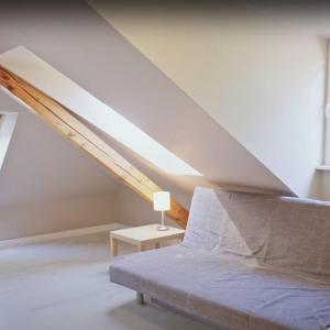 a room with a bed and a table in a attic at Apartamenty Za Regą in Mrzeżyno