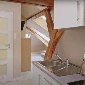 a kitchen with a sink and a attic at Apartamenty Za Regą in Mrzeżyno