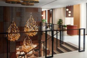 a lobby with a staircase and chandeliers at Courtyard by Marriott Yerevan in Yerevan