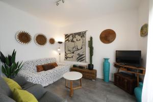 a living room with a couch and a tv at Royal Cabanas Golf in Cabanas de Tavira