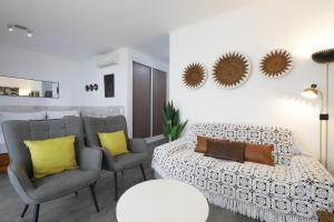 uma sala de estar com duas cadeiras e um sofá em Royal Cabanas Golf em Cabanas de Tavira