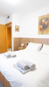 białe łóżko z ręcznikami na górze w obiekcie Melannie's Apartment w Bergamo