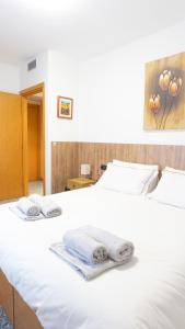 a white bed with towels on top of it at Melannie's Apartment in Bergamo