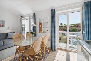 a kitchen and living room with a table and chairs at Apartment by the beach - Great facilities and consumption included in Allinge
