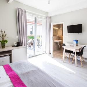 a bedroom with a bed and a desk and a table at Apartamenty Za Regą in Mrzeżyno