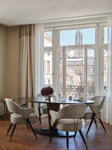 una sala da pranzo con tavolo, sedie e una finestra di Rosewood Vienna a Vienna