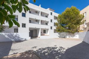 an external view of a white building at Es Dolç Apartments by YouRoom in Colonia Sant Jordi
