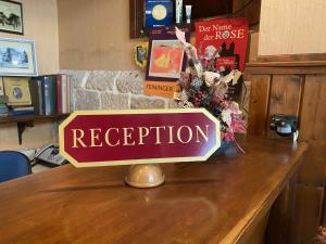 uma placa que diz recepção em uma mesa em Hotel garni Am Dippeplatz em Quedlinburg