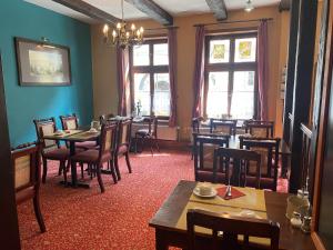 a dining room with tables and chairs and windows at Hotel garni Am Dippeplatz in Quedlinburg