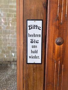 Ein Schild an einer Tür, auf dem steht: in der Unterkunft Hotel garni Am Dippeplatz in Quedlinburg