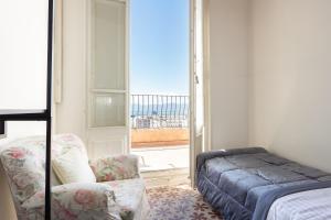 sypialnia z łóżkiem, krzesłem i oknem w obiekcie La dolce vita w Cagliari