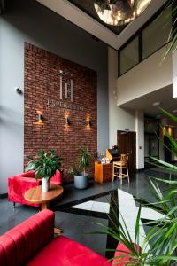 - un hall avec un canapé rouge et un mur en briques dans l'établissement Hotel Esperanto, à Białystok