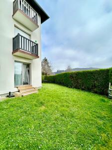 uma casa branca com um relvado verde em frente em Superbe appartement avec jardin ensoleillé em Blonville-sur-Mer