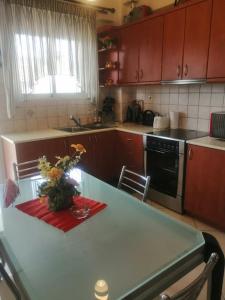 uma cozinha com uma mesa com um vaso de flores em Zeus_Apartment_Ioannina em Neochorópoulon