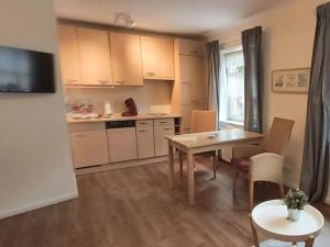 eine Küche mit einem Tisch und einem Esszimmer in der Unterkunft Holiday apartment Waterdelle in Borkum