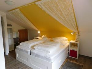 1 dormitorio con 1 cama blanca grande y techo amarillo en Holiday home Big Lady, en Wettringen