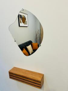 a mirror hanging on a wall with a bench at Hacienda Residence - Solar Energized in Yaoundé
