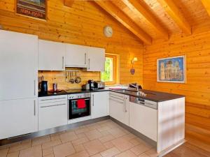 cocina con electrodomésticos blancos y techo de madera en Chalet Bryher en Les Collons