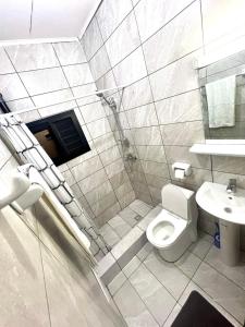 ein Bad mit einem WC und einem Waschbecken in der Unterkunft Hacienda Residence in Jaunde