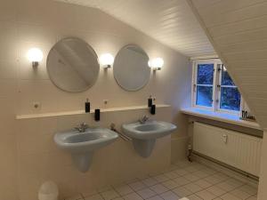 a bathroom with two sinks and two mirrors at Holiday apartment Möwennest in Lindholm