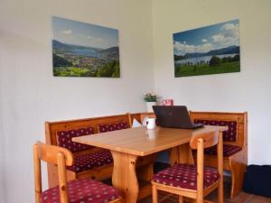 a dining room table with a laptop on it at Holiday apartment Sonia on the lake in Bad Wiessee