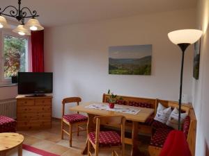a living room with a table and chairs and a television at Holiday apartment Sonia on the lake in Bad Wiessee