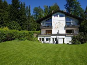 a large house with a large green field in front of it at Holiday apartment Sonia on the lake in Bad Wiessee